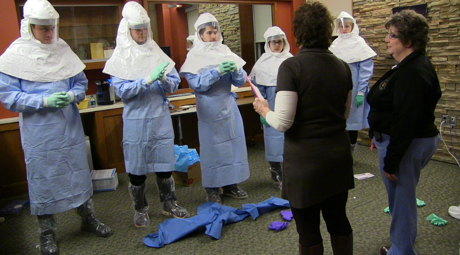 Trainees in full biohazard protective gear and hoods. 